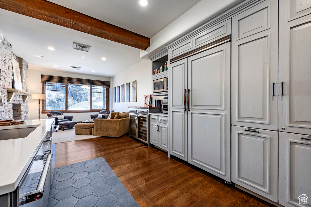 Kitchen featuring stainless steel microwave, open floor plan, light countertops, dark wood-style flooring, and recessed lighting