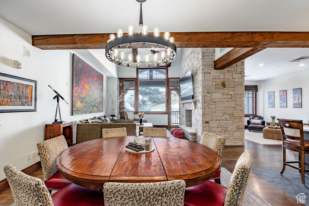 Dining room featuring beam ceiling, a chandelier, wood finished floors, and healthy amount of natural light