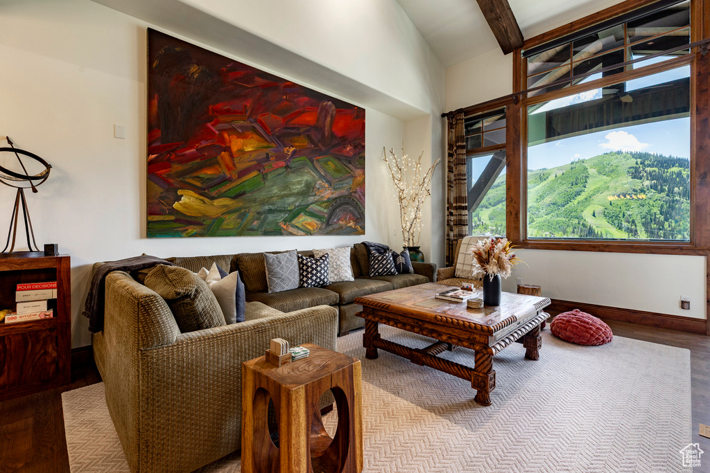 Living room featuring wood finished floors, beamed ceiling, and high vaulted ceiling