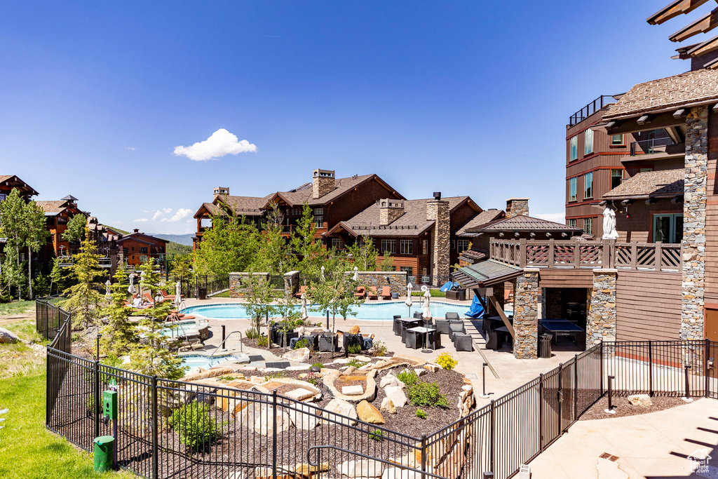 Surrounding community featuring a pool, a patio, and a residential view