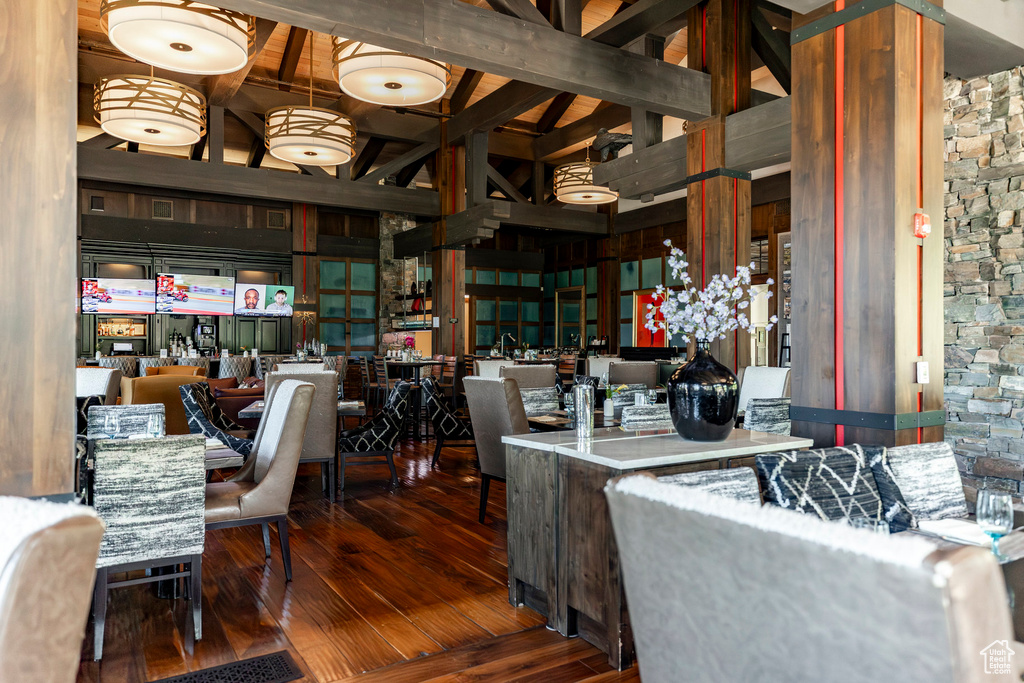 Home office featuring high vaulted ceiling, hardwood / wood-style flooring, and beam ceiling