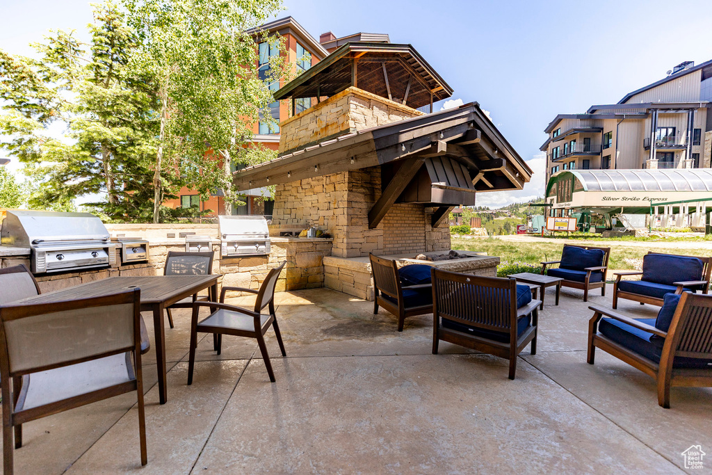 View of patio with exterior kitchen, an outdoor hangout area, and outdoor dining area