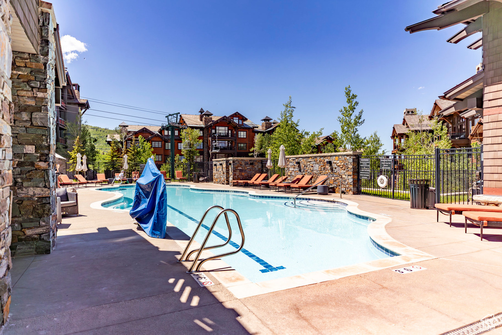 Community pool featuring a patio area and a residential view