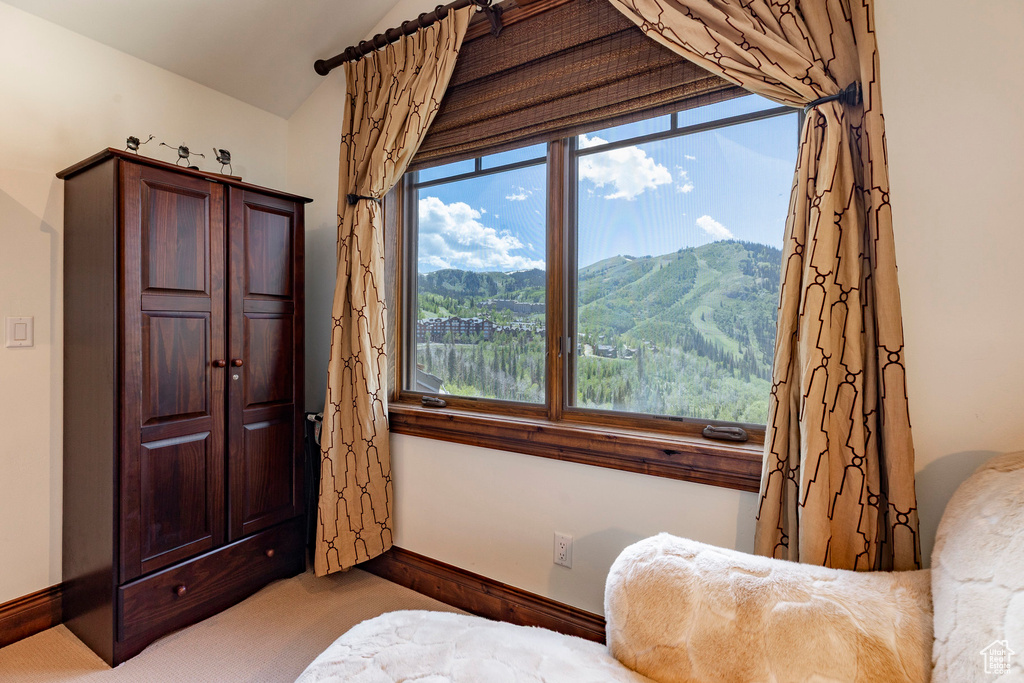 Living area with carpet, lofted ceiling, and a mountain view