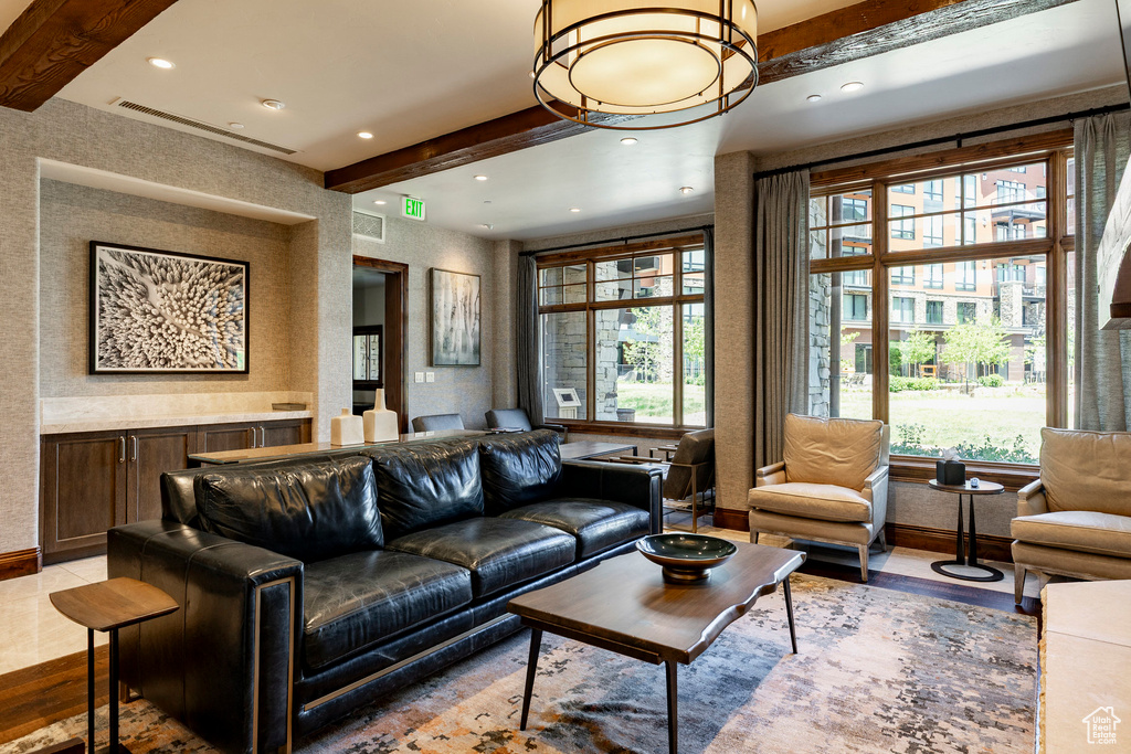 Living room with beamed ceiling, healthy amount of natural light, recessed lighting, and wood finished floors