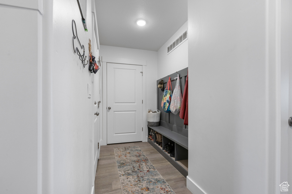 Mudroom with light wood-type flooring and baseboards