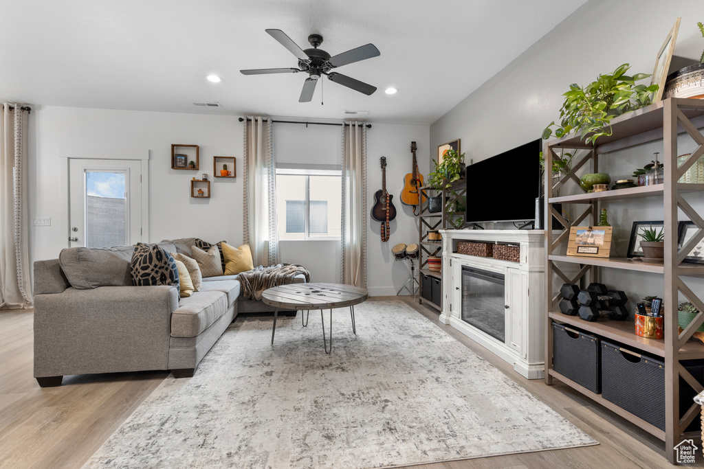 Living area with wood finished floors, a ceiling fan, and recessed lighting