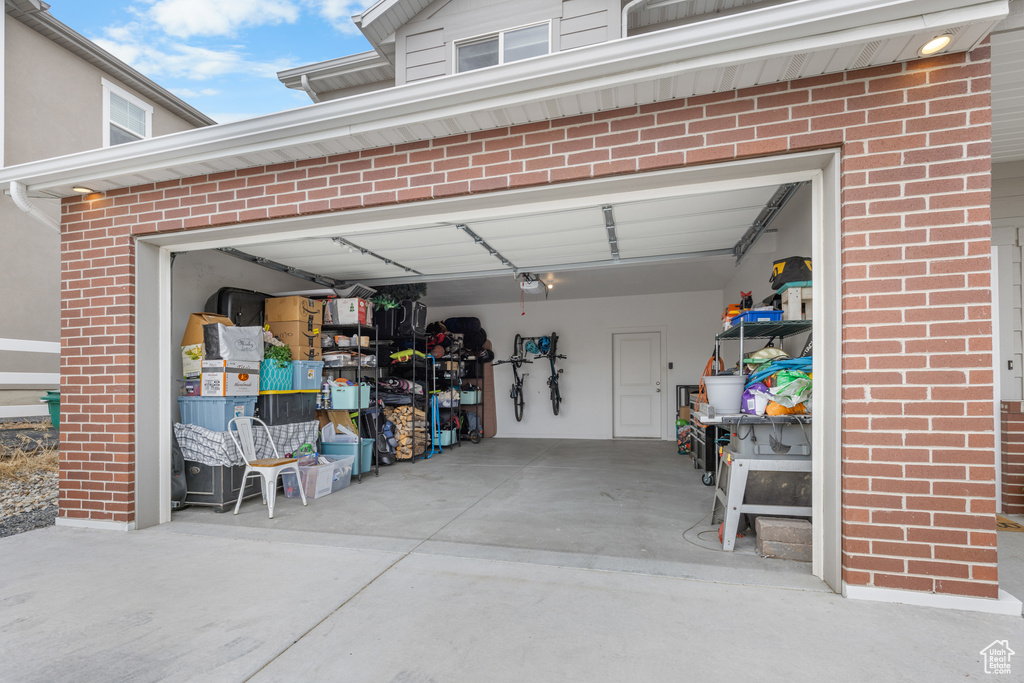 Garage featuring a garage door opener and driveway