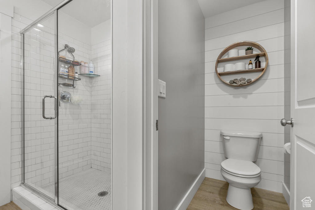 Bathroom with wood finished floors and a stall shower