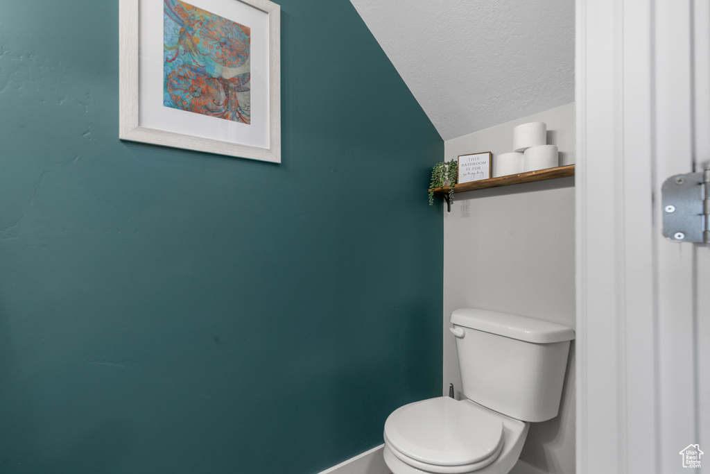Bathroom featuring a textured ceiling and lofted ceiling