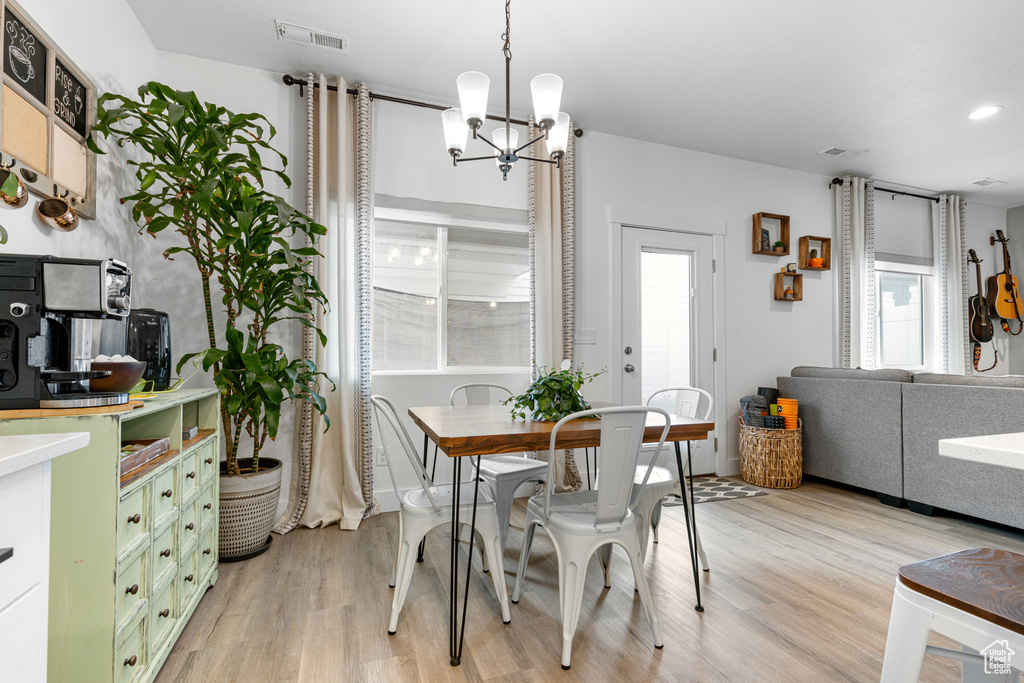 Dining room with a chandelier, light wood-style floors, and recessed lighting