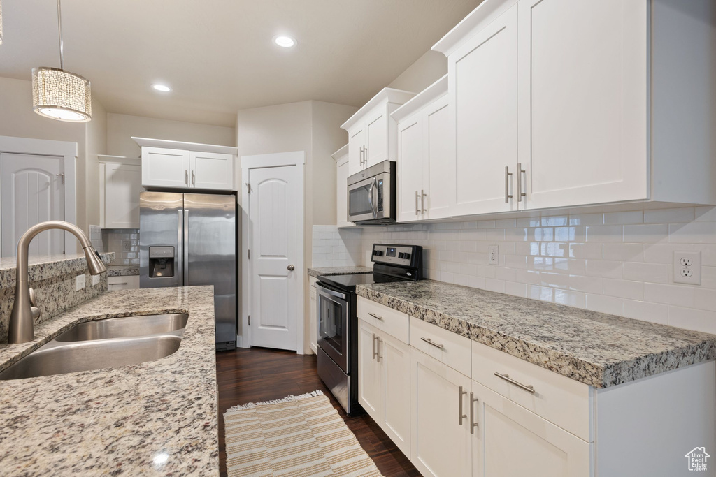 Kitchen featuring stainless steel appliances, white cabinets, backsplash, and recessed lighting