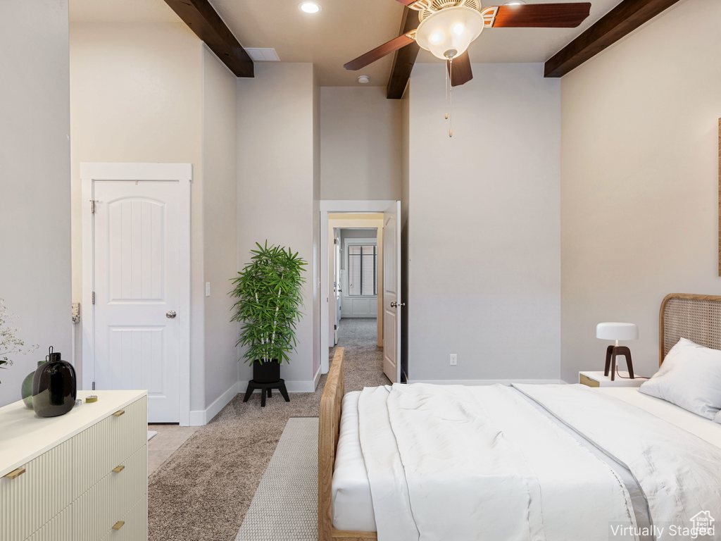 Bedroom featuring light colored carpet, beamed ceiling, recessed lighting, a ceiling fan, and a towering ceiling