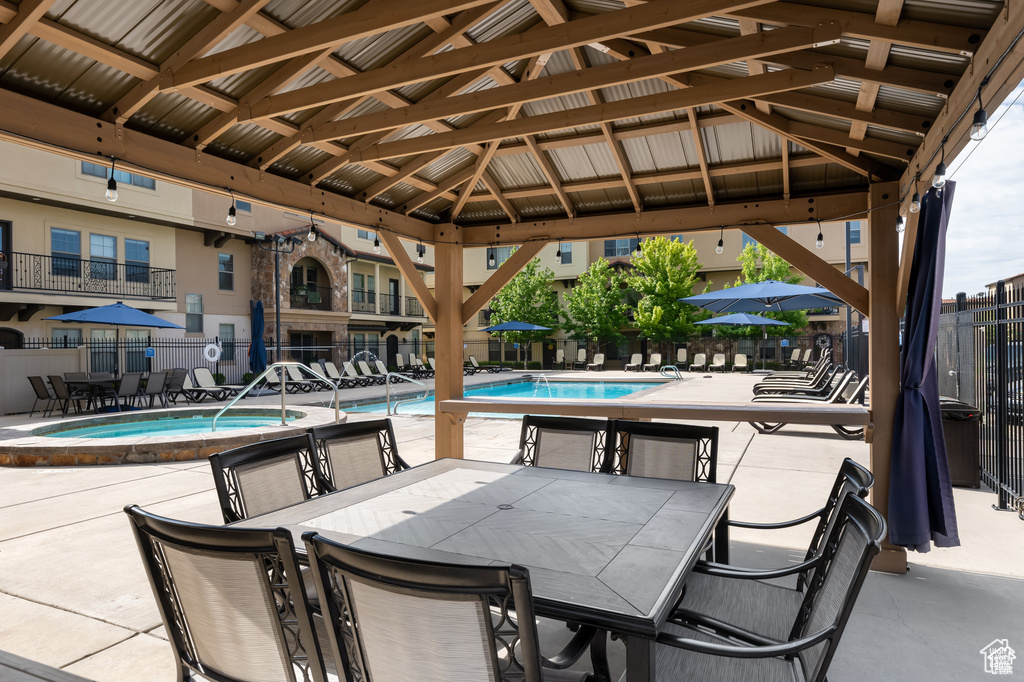 View of patio / terrace featuring a community pool, outdoor dining area, and a gazebo