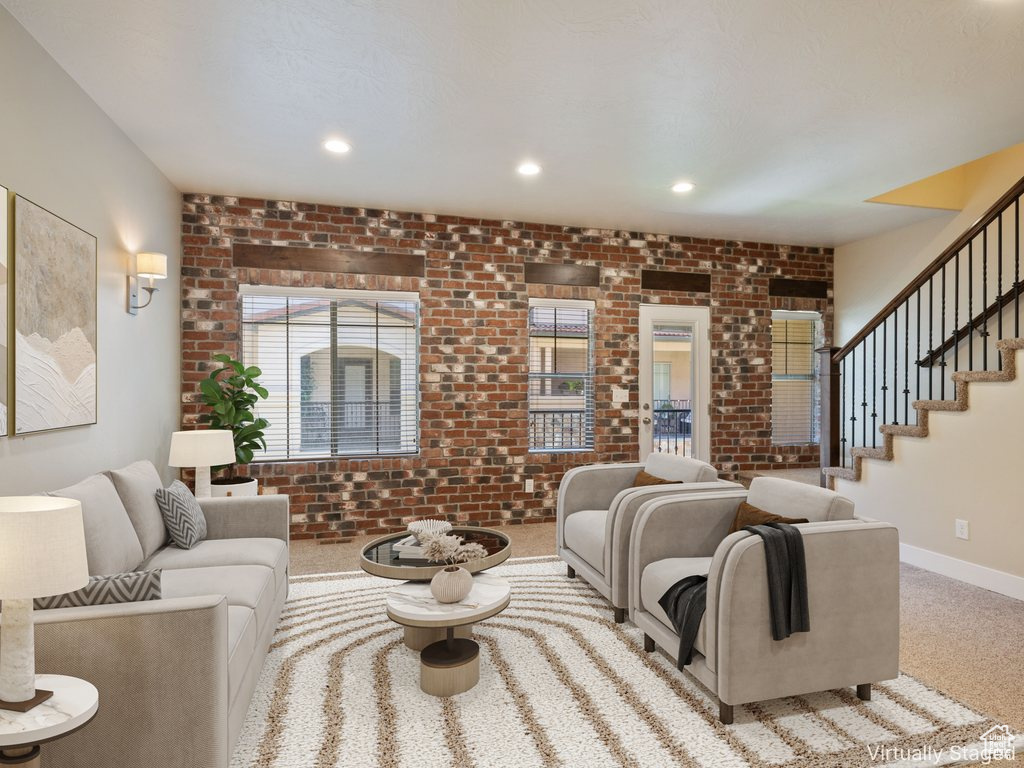 Living room featuring brick wall, carpet flooring, stairway, and recessed lighting