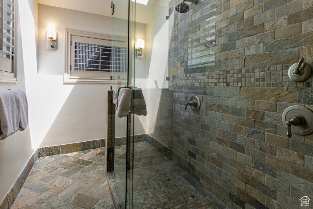 Bathroom with stone tile flooring and a shower stall