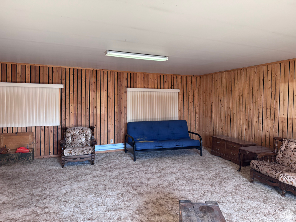 Sitting room with carpet flooring and wood walls