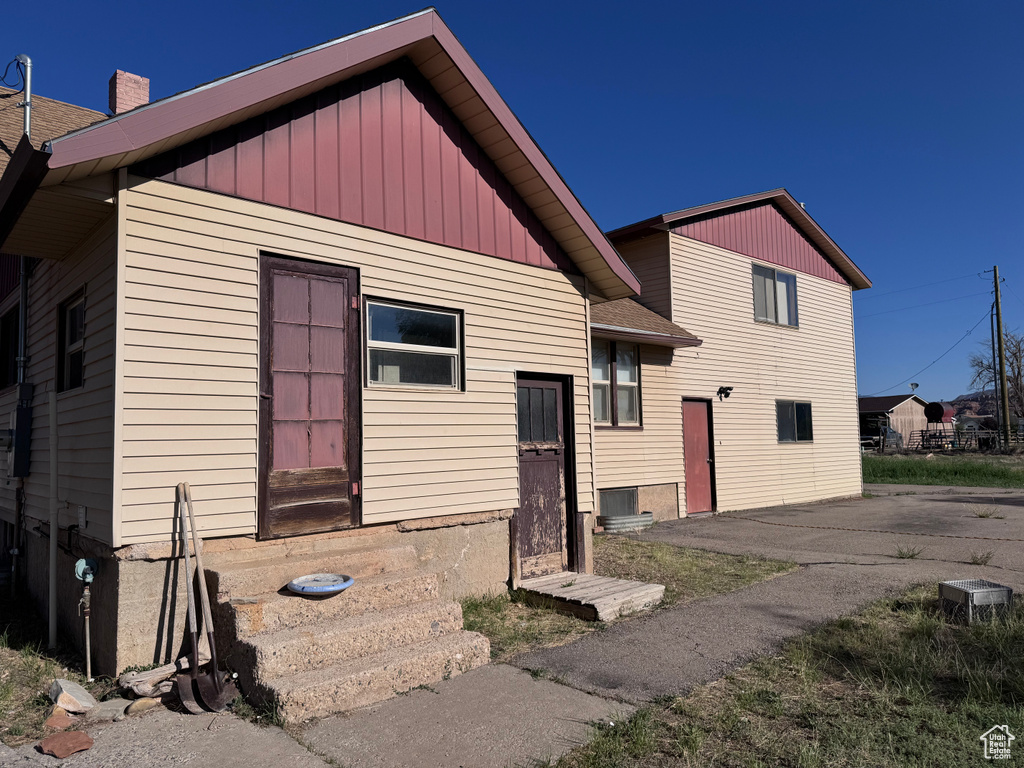 View of front of home with entry steps and a chimney