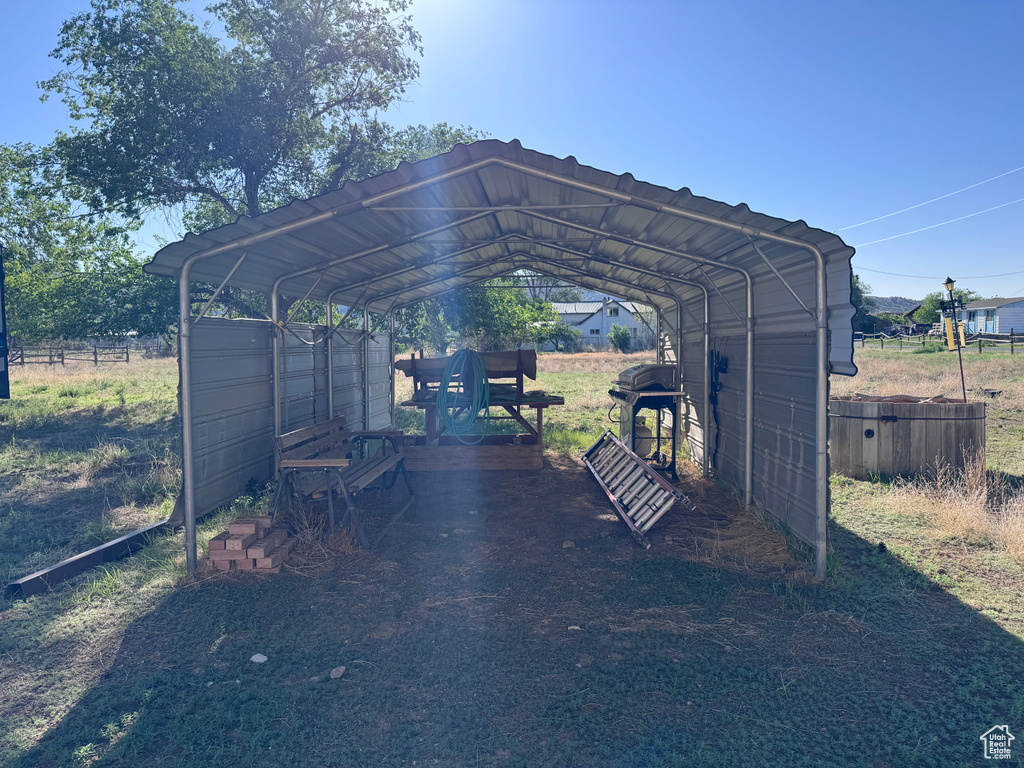 View of parking / parking lot featuring a carport