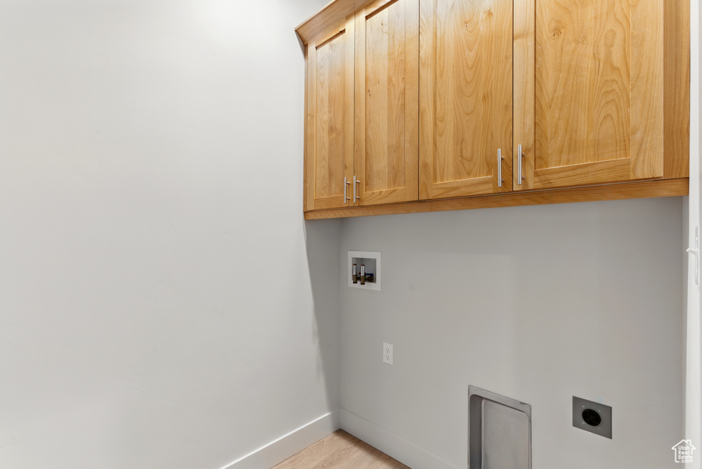 Washroom featuring cabinet space, washer hookup, electric dryer hookup, and light wood-type flooring