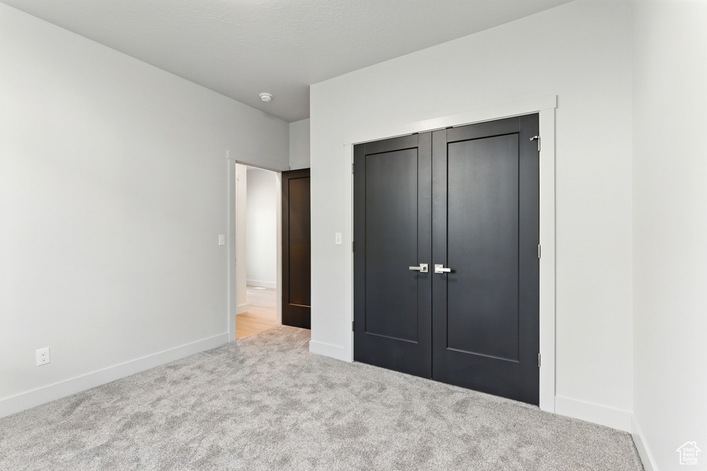 Unfurnished bedroom with carpet flooring and a closet