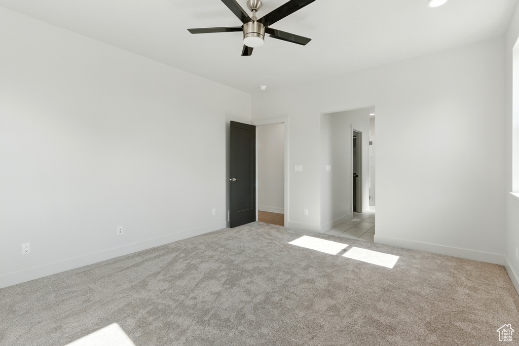 Unfurnished bedroom featuring light colored carpet and ceiling fan