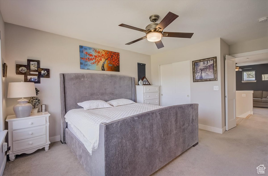 Bedroom featuring light carpet, a closet, and ceiling fan