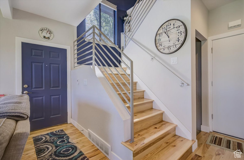 Foyer with light wood finished floors and stairway