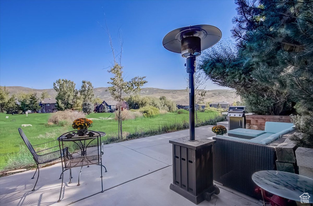 View of patio with a mountain view and area for grilling