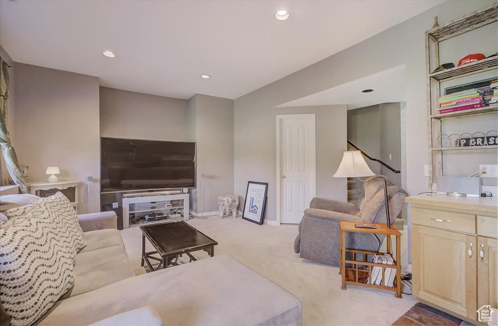Living area with light colored carpet and recessed lighting