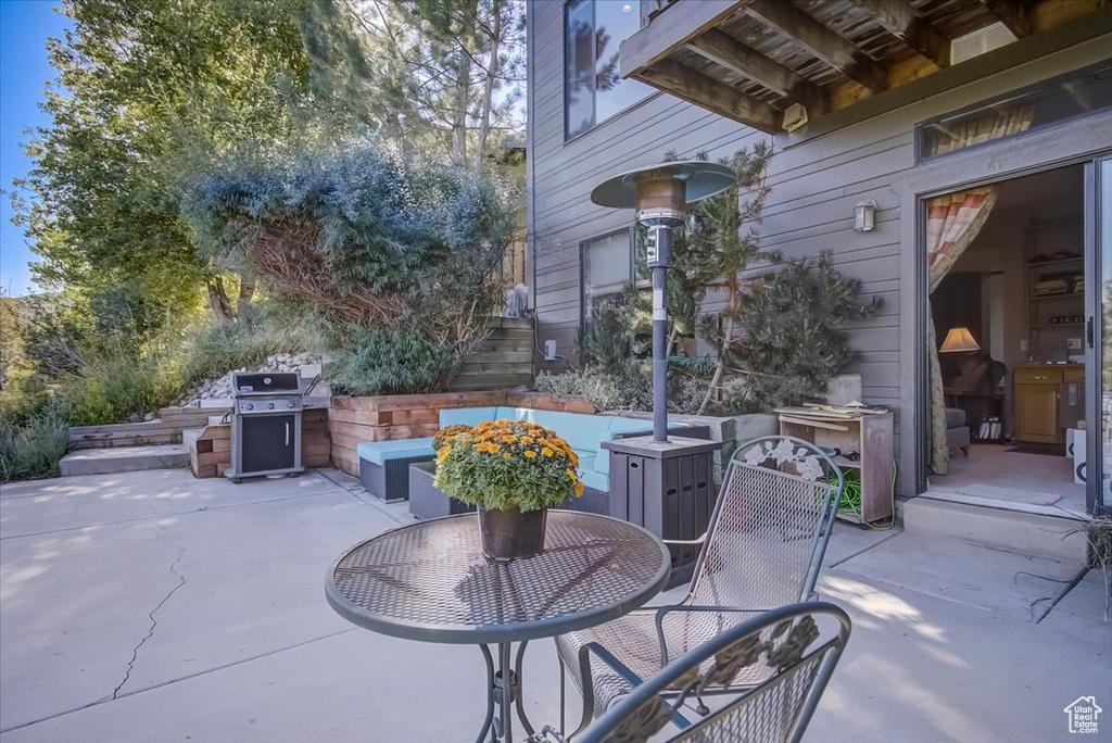 View of patio featuring outdoor dining area, stairs, and grilling area