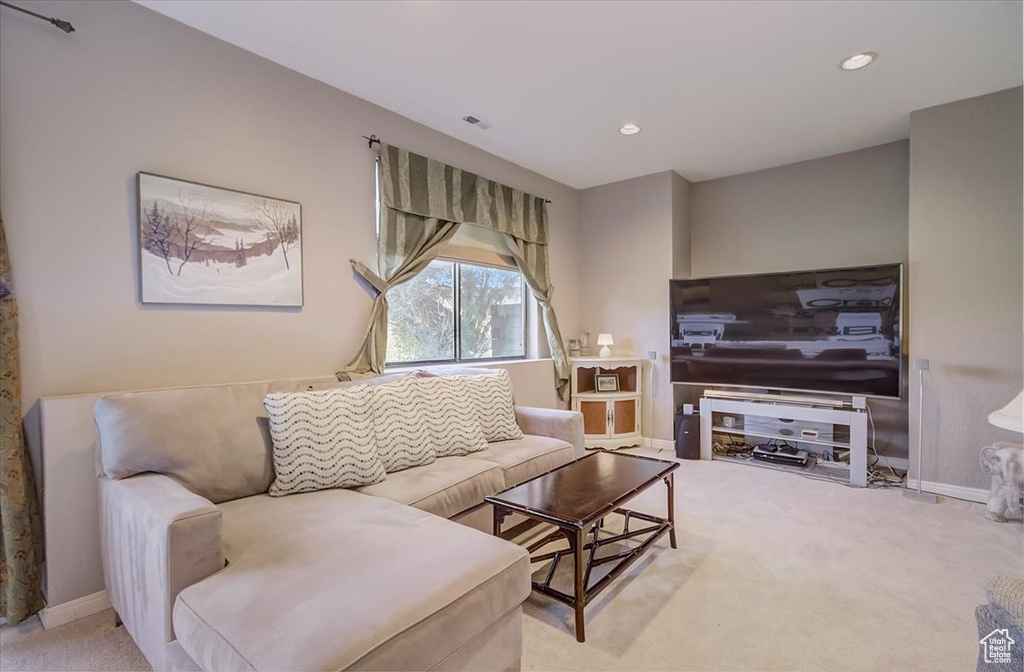 Living room featuring light colored carpet and recessed lighting
