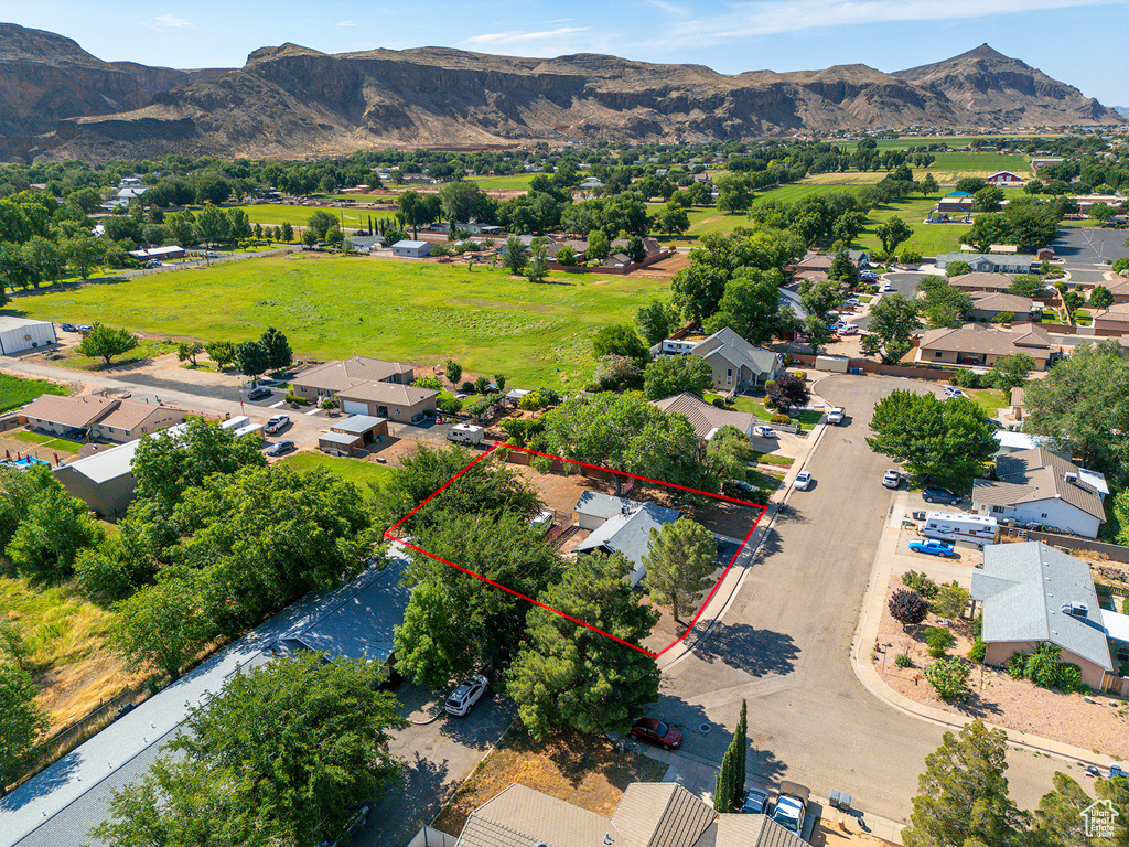 Aerial perspective of suburban area featuring a mountain backdrop and property boundaries highlighted