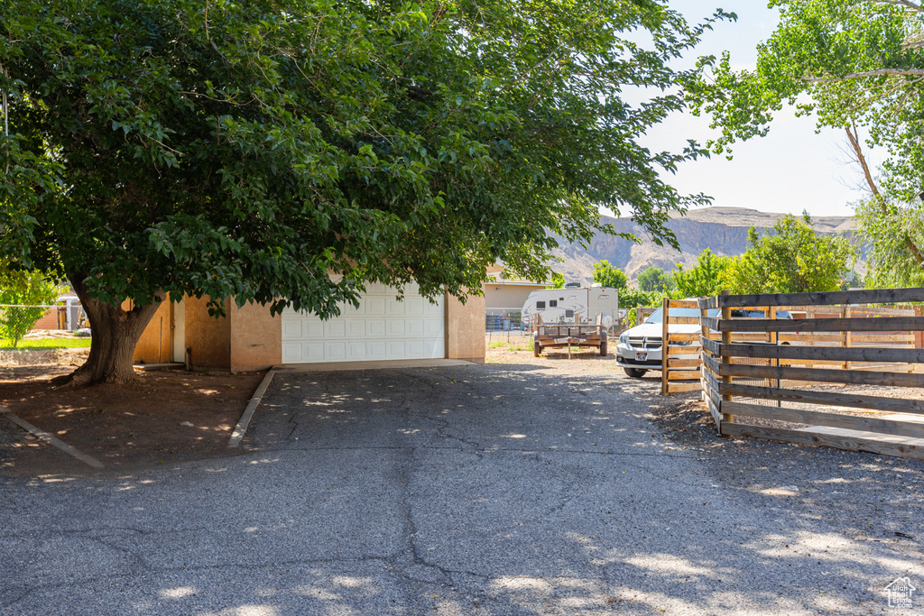 View of side of property with a mountain view, stucco siding, a garage, and an outbuilding