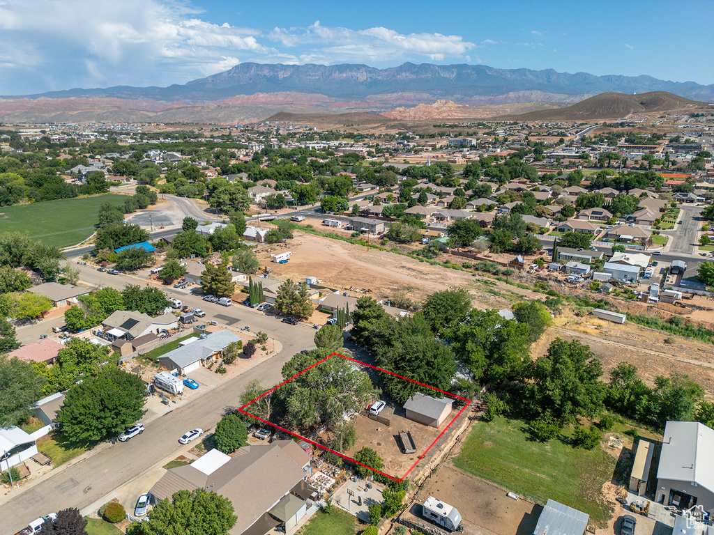 Aerial perspective of suburban area featuring a mountainous background and property boundaries highlighted