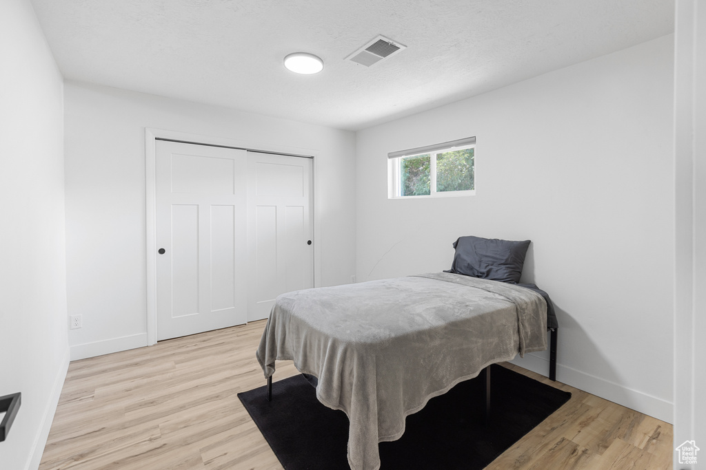 Bedroom featuring light wood-style flooring and a closet