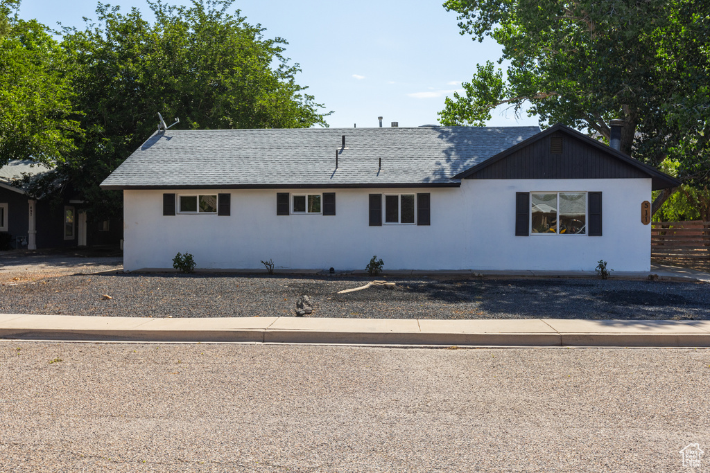 Single story home featuring roof with shingles and stucco siding