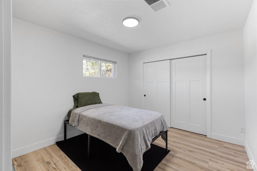 Bedroom featuring light wood-type flooring and a closet