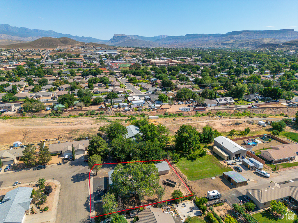 Aerial view of residential area with a mountainous background and property boundaries highlighted