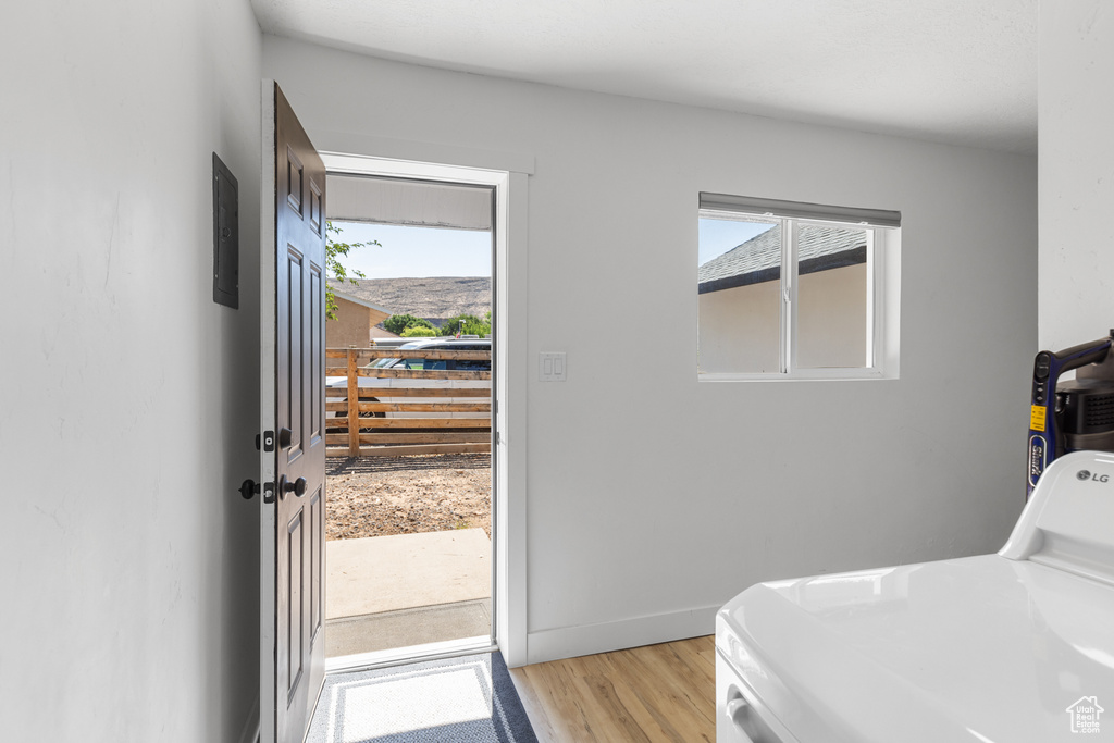 Laundry room with washer / clothes dryer and light wood finished floors