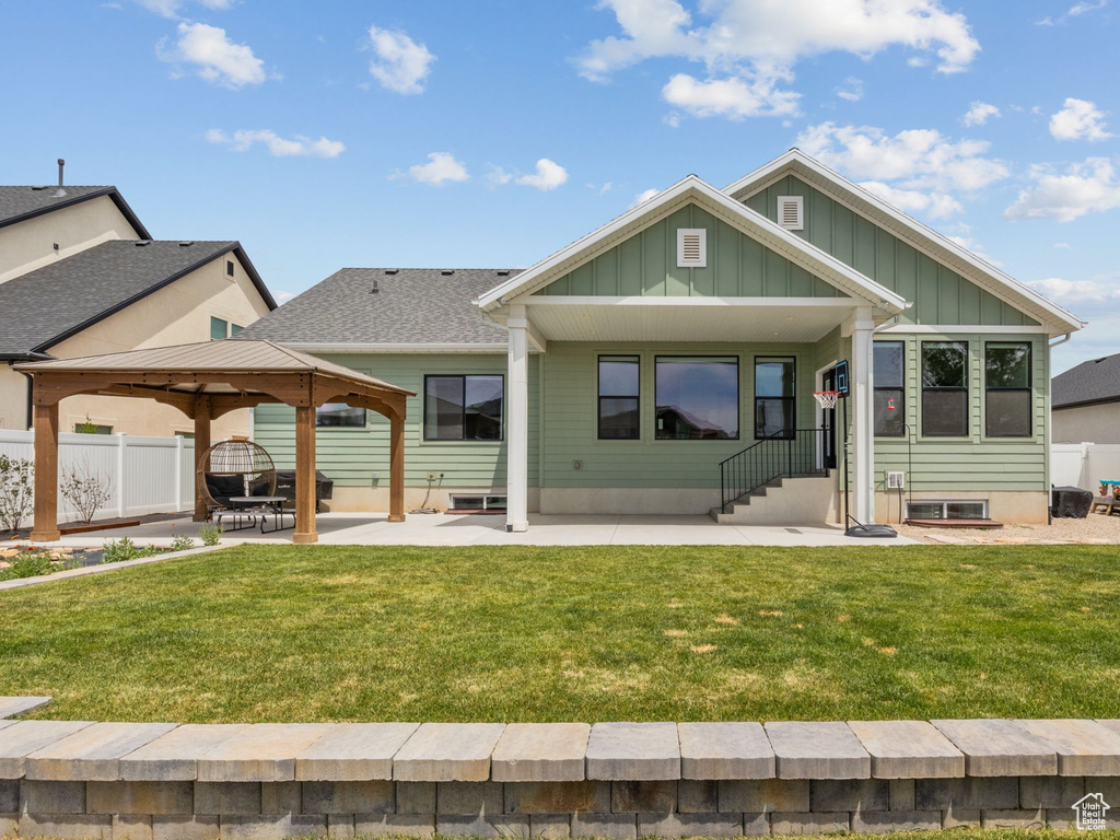 Back of property with board and batten siding, a gazebo, a patio area, and entry steps