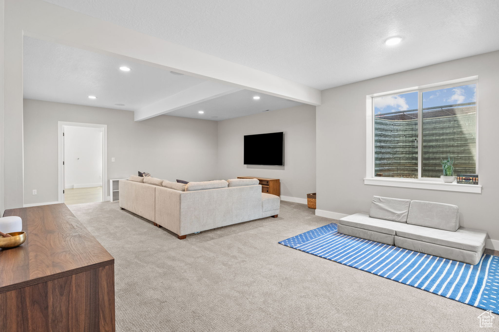 Living area featuring recessed lighting, carpet flooring, and beamed ceiling
