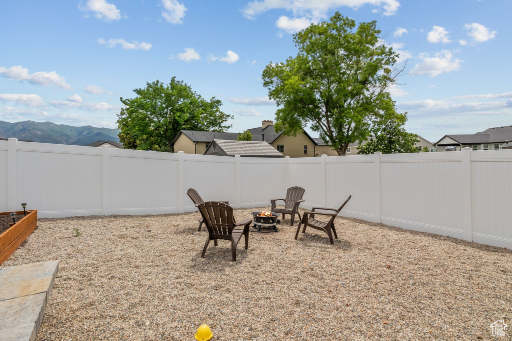 Fenced backyard featuring a fire pit and a mountain view