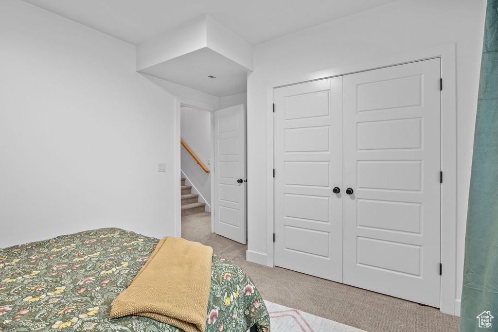 Carpeted bedroom featuring a closet