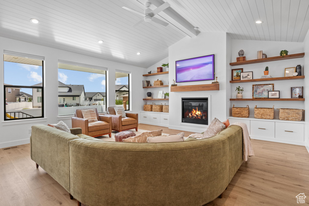 Living room with light wood-style flooring, a glass covered fireplace, a ceiling fan, recessed lighting, and wood ceiling