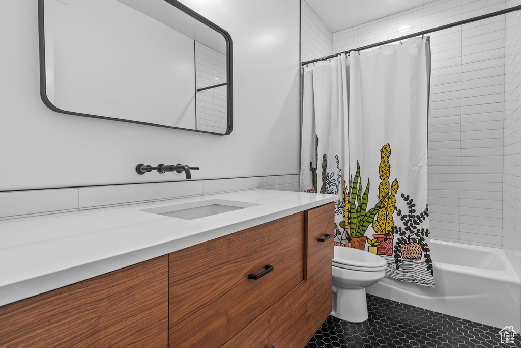Full bathroom with vanity, shower / tub combo with curtain, and tile patterned flooring