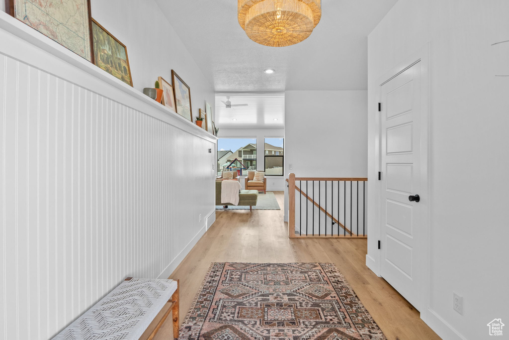 Hallway featuring an upstairs landing, wood finished floors, and recessed lighting