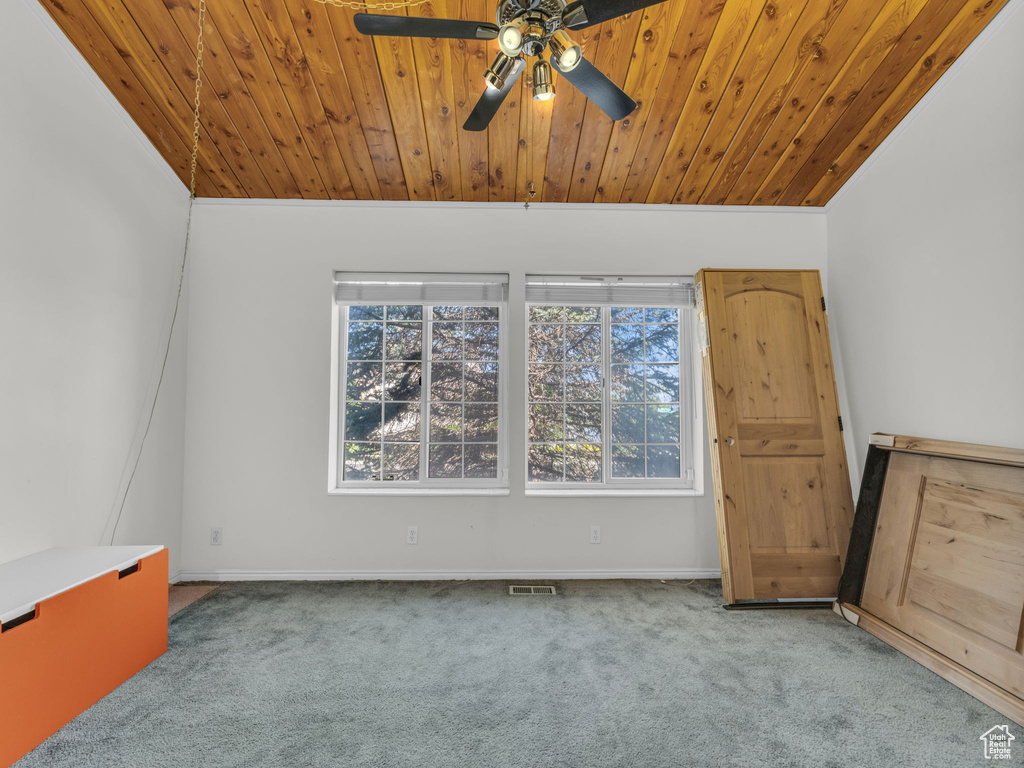 Carpeted spare room with ceiling fan and wooden ceiling