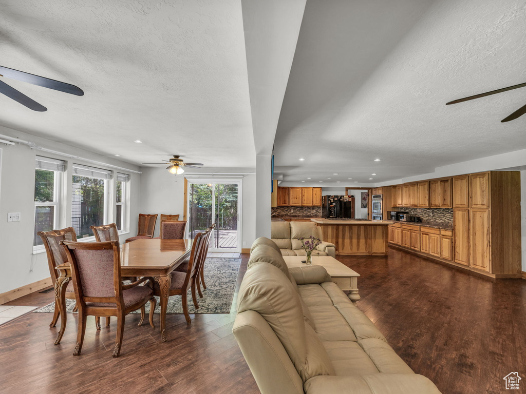 Dining space with a ceiling fan, a textured ceiling, recessed lighting, and dark wood finished floors