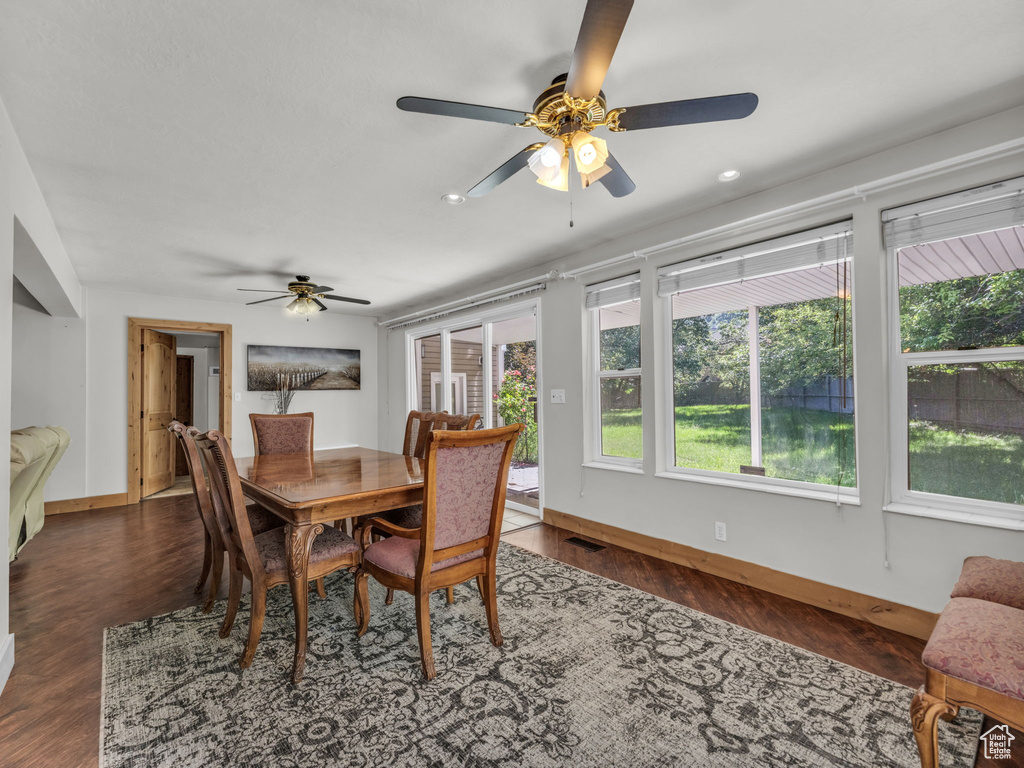 Dining room with a ceiling fan, healthy amount of natural light, and dark wood-style floors